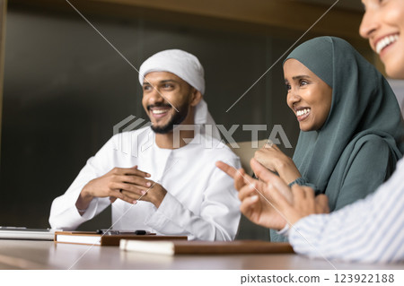 Group of multinational teammates laughing at briefing in office Group of multinational teammates laughing at briefing in office 123922188