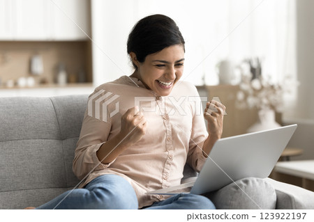 Excited young woman look on notebook screen celebrate success Excited young woman look on notebook screen celebrate success 123922197