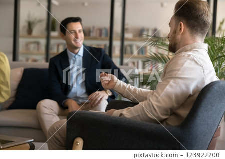Two young men rest at library relaxation area hold dialogue Two young men rest at library relaxation area hold dialogue 123922200