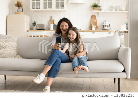 Cute little girl with loving mother taking selfie on phone Cute little girl with loving mother taking selfie on phone 123922235