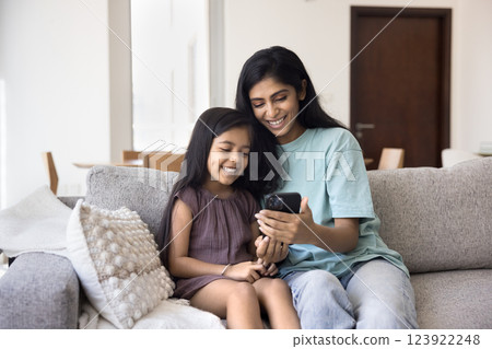 Indian mother spend time with little 5s daughter using smartphone 123922248