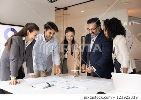 Multiethnic team of happy coworkers analyzing sales statistic data 123922339