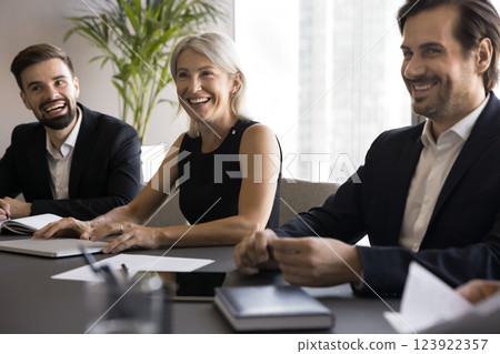 Happy teammates negotiate, laughing, joking during meeting 123922357