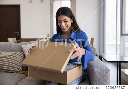 Woman opening cardboard box, feel satisfied with express delivery services 123922387