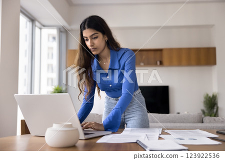 Woman analyzing data, reviewing information, planning strategy working on laptop Woman analyzing data, reviewing information, planning strategy working on laptop 123922536
