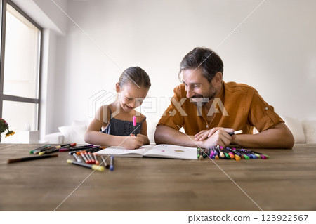 Dad and daughter drawing in paper album with colorful felt-pens 123922567