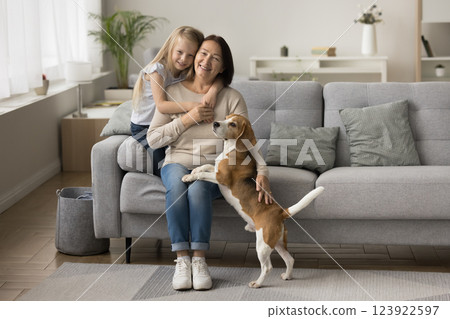 Girl cuddling older loving granny posing for camera with dog 123922597