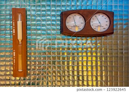 Hourglass for bath, Sauna thermometer and hygrometer mounted on blue mosaic tile wall. Wooden instruments measuring temperature and humidity with inscription "Sauna thermometer" and "Sauna hygrometer" Hourglass for bath, Sauna thermometer and hygrometer mounted on blue mosaic tile wall. Wooden instruments measuring temperature and humidity with inscription "Sauna thermometer" and "Sauna hygrometer" 123922645