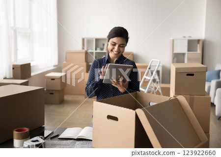 Happy young woman web shop manager work with digital tablet Happy young woman web shop manager work with digital tablet 123922660