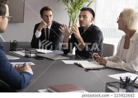 Diverse age workers listen to young manager speaking at boardroom 123922682