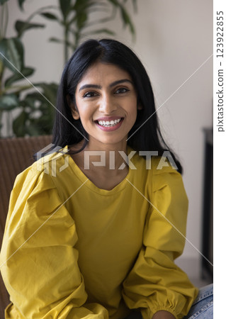 Vertical portrait Indian woman sitting in chair, looking at camera 123922855