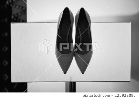 Beige high-heeled shoes with a pointed end in the studio on a yellow glowing background. The concept of selling or wedding shoes. Perfect for the fashion enthusiasts and brides-to-be seeking elegance. Beige high-heeled shoes with a pointed end in the studio on a yellow glowing background. The concept of selling or wedding shoes. Perfect for the fashion enthusiasts and brides-to-be seeking elegance. 123922893