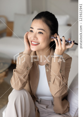 Happy young Asian woman holding mobile phone at ear 123922941