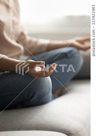 Closeup young woman sit on couch rest do yoga meditate 123922961