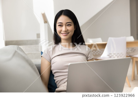 Asian woman relaxed and contented sit on sofa with laptop 123922966
