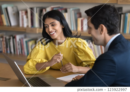 Young female student discuss project with male tutor using laptop 123922997