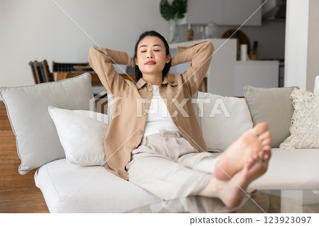 Sleepy tired young Asian girl stretching body with closed eyes 123923097