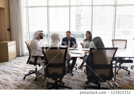 Five multicultural businesspeople negotiating gathered in conference room 123923152