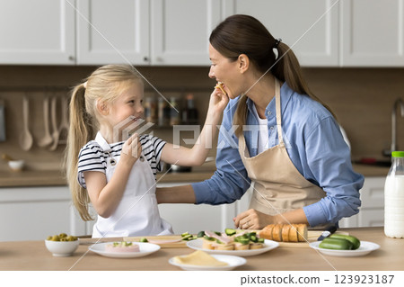 Cute little child feeding small snack to lovely mom Cute little child feeding small snack to lovely mom 123923187