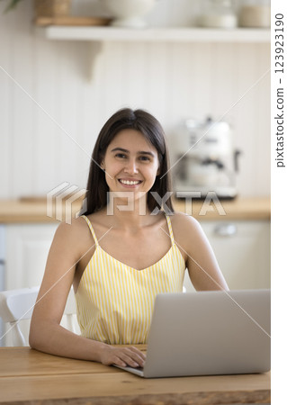 Happy young lady sitting by notebook at home office desk 123923190