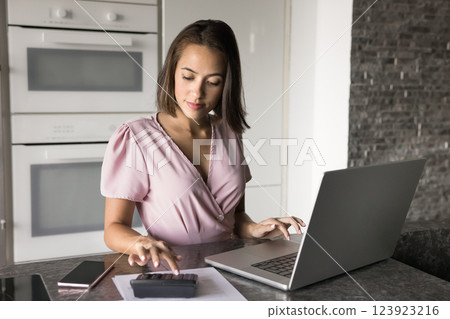 Focused young woman planning budget and managing personal finances Focused young woman planning budget and managing personal finances 123923216