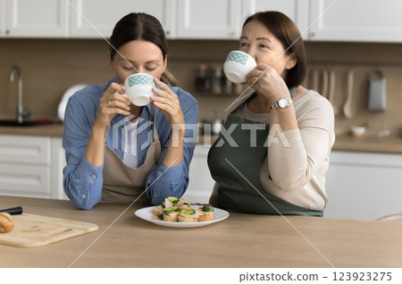 Family drinking morning tea, eating sandwiches in the kitchen Family drinking morning tea, eating sandwiches in the kitchen 123923275