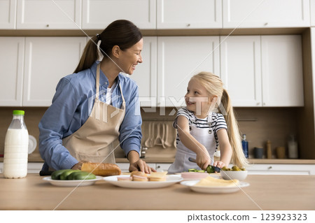 Lovely kid enjoying cookery time with loving mother 123923323