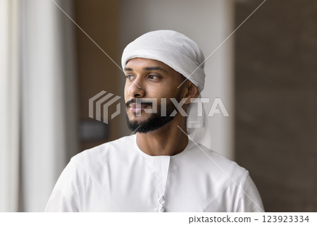Confident Middle Eastern man stands indoor, gazing thoughtfully into distance Confident Middle Eastern man stands indoor, gazing thoughtfully into distance 123923334