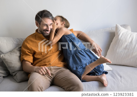 Cute little girl whispering on loving fathers ear a secret 123923381