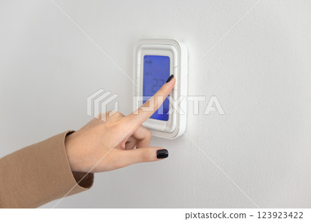 Hand of woman using wall mounted smart home device Hand of woman using wall mounted smart home device 123923422