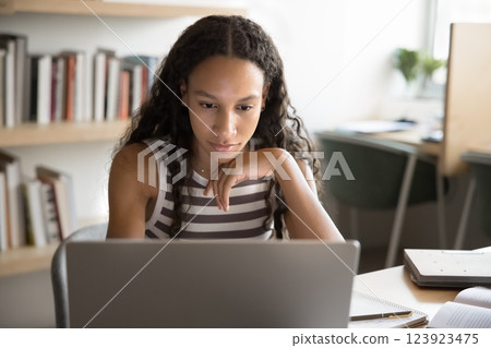 Student engaged in e-learning seated table with modern laptop 123923475