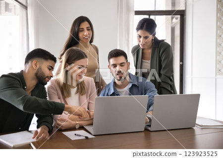 Five colleagues take part in collaborative work gathered around laptops 123923525