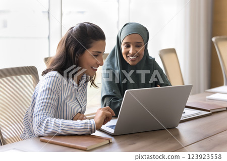 Two multicultural women engaged in collaborative activity on laptop Two multicultural women engaged in collaborative activity on laptop 123923558
