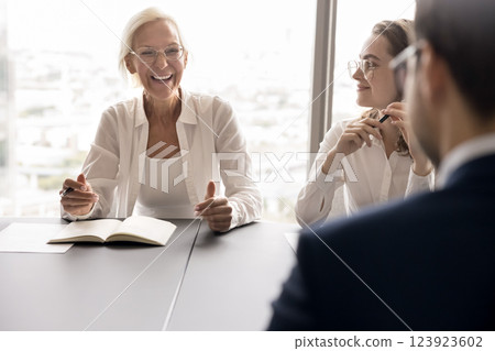 Joyful senior female employee express funny idea on staff meeting 123923602