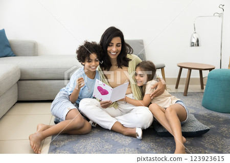 Two kids and mother holding handmade postcard 123923615