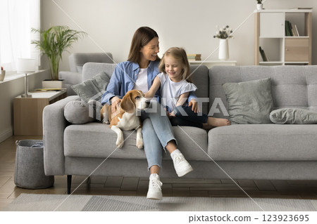 Young woman resting with little daughter and cute beagle dog 123923695
