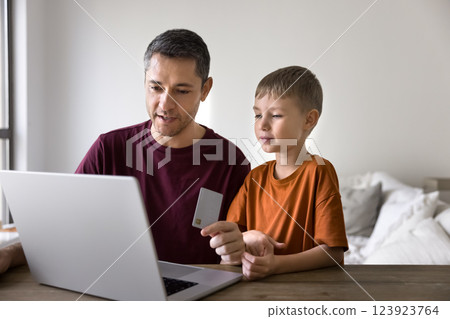 Father and little son buying goods using card and laptop 123923764