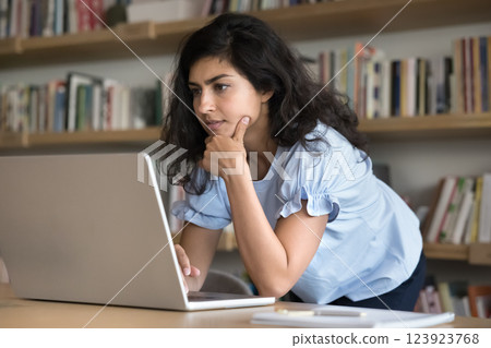 Young woman student work on project in library using notebook 123923768