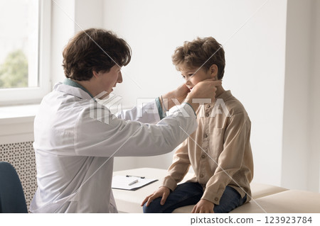 Young male doctor family therapist checking up sick little boy 123923784