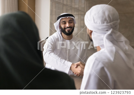 Arabian businessman shake hand clients, welcoming married couple start meeting 123923793