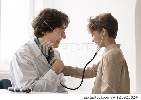 Laughing boy pretend doc listen to physician heart using phonendoscope Laughing boy pretend doc listen to physician heart using phonendoscope 123923824