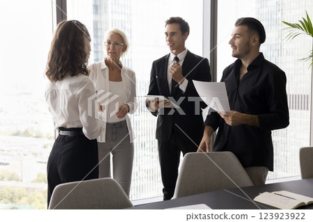 Friendly diverse teammates hold informal conversation discuss work in office 123923922