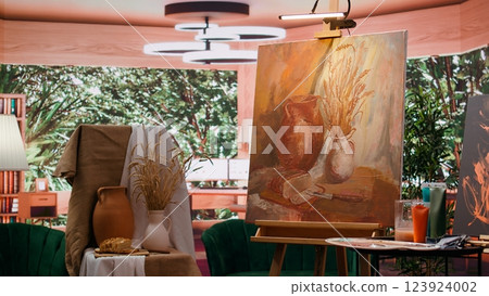 Empty art and craft workshop with a rustic beautiful painting on canvas, creative work with watercolor paint in a modern contemporary atelier. Artistic masterpiece with paint tubes and tools. Empty art and craft workshop with a rustic beautiful painting on canvas, creative work with watercolor paint in a modern contemporary atelier. Artistic masterpiece with paint tubes and tools. 123924002