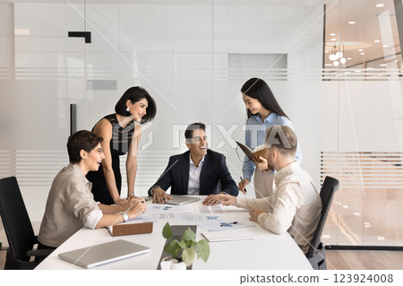 Diverse multiethnic workers group gather by table for informal conversation 123924008
