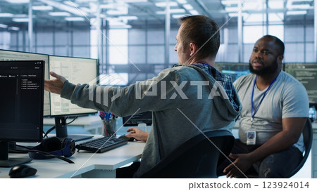 Manager admonishing programmer after making error damaging high tech data center. Supervisor scolding IT staff member after doing mistake in server room affecting supercomputers, camera A 123924014