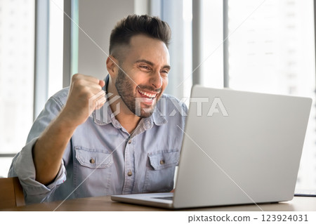 Man celebrating positive news, job offer, promotion, project approval 123924031