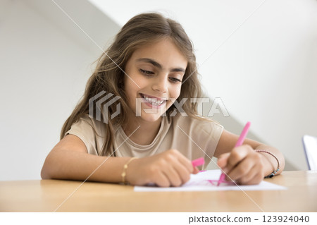 Closeup of little girl drawing with pink marker on paper 123924040