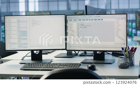 Lines of code running on computer screens in data center, used for troubleshooting rackmounts in server rows. Close up shot of script working on PC monitors upgrading hardware, handheld camera shot 123924076