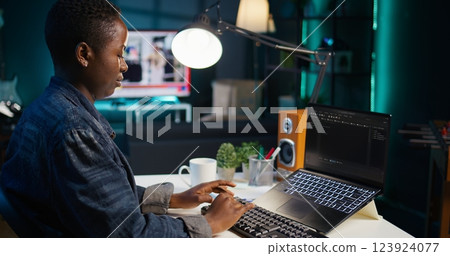 Teleworker in living room office using laptop to do coding for software developing, handheld camera shot. Remote employee typing on device keyboard, solving tasks in apartment, camera B close up Teleworker in living room office using laptop to do coding for software developing, handheld camera shot. Remote employee typing on device keyboard, solving tasks in apartment, camera B close up 123924077