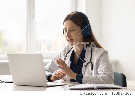 Young woman doctor in headset speak with patient by videocall Young woman doctor in headset speak with patient by videocall 123924162